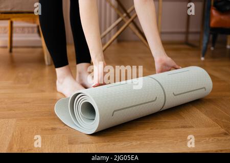 Fit Mädchen Rollen eine Yoga-Matte Stockfoto