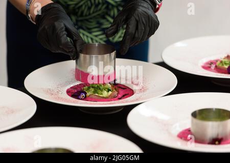 Chef serviert Suppe mit eingelegten Rüben. Vorbereitung von Borscht. . Polnische Küche. Gesunde Ernährung. Rübensaft. Natürliche Behandlung. Stockfoto