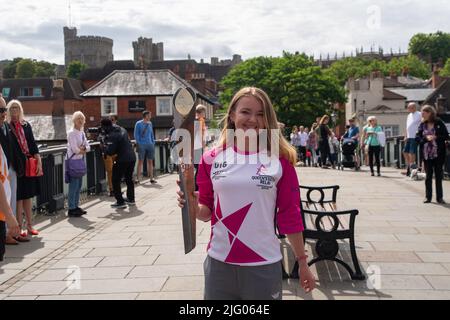 Eton, Windsor, Britannien. 6.. Juli 2022. Der Schlagträger Jemma Wood steht auf der Windsor Bridge mit Blick auf Windsor Castle. Jemma wurde von PwC für die Stabführung nominiert. Jemma hat eine zystische Fibrose und hat 740 Tage ihres Lebens im Krankenhaus verbracht, 530 Tage lang Verneblern/Physio gewidmet und nimmt 720 Tabletten pro Monat. Trotzdem hat Jemma die Ehrenmitgliedschaft im Turnteam der University of London erhalten und über £300.000 für den Cystic Fibrosis Trust gesammelt. Quelle: Maureen McLean/Alamy Live News Stockfoto