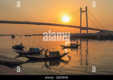 Kalkutta, 20, März, 2013; Reflexionen von lokalen Booten und Vidyasagar Setu, Brücke gegen Sonnenuntergang Hintergrund im Fluss Hooghly, Kalkutta, Indien Stockfoto