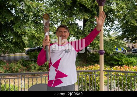 Windsor, Großbritannien. 6.. Juli 2022. Der Schlagstock-Träger Judo Olympian Ray Stevens trägt den Schlagstock, während er aus dem Bandstand in Alexandra Gardens, Windsor, zu den Massen winkt. Der Birmingham 2022 Queen's Baton Relay ist die Isle of Wight. Quelle: Maureen McLean/Alamy Live News Stockfoto