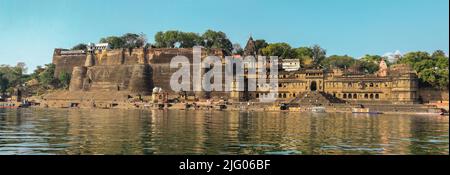 Maheshwar,13,Februar ,2010; Reflexion von Maheshwar Fort und Tempelkomplex auf dem Ufer des heiligen Flusses Narmada, Maheshwar Madhya Pradesh, Indien Stockfoto