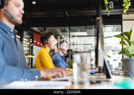 Junge kaukasische weibliche Kundendienstführerin, die im Büro am Computer arbeitet Stockfoto