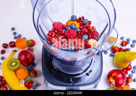 Frischer Obst-Smoothie im Mixer. Vorbereitung eines frischen Getränks voller Vitamine für eine gesunde Ernährung. Stockfoto