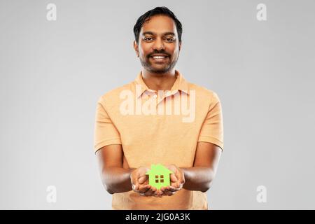 Lächelnder inder mit der Ikone des grünen Hauses Stockfoto