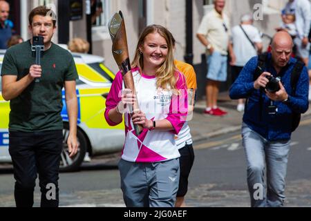 Windsor und Eton, Großbritannien. 6.. Juli 2022. Batonbearer Jemma Wood trägt den Baton der Königin entlang der Eton High Street in Richtung Windsor Bridge. Der Queen's Baton Relay befindet sich derzeit auf einer 25-tägigen Tour durch die englischen Regionen auf dem Weg zu den Commonwealth Games. Kredit: Mark Kerrison/Alamy Live Nachrichten Stockfoto