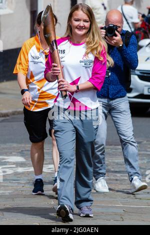 Windsor und Eton, Großbritannien. 6.. Juli 2022. Batonbearer Jemma Wood trägt den Baton der Königin entlang der Eton High Street in Richtung Windsor Bridge. Der Queen's Baton Relay befindet sich derzeit auf einer 25-tägigen Tour durch die englischen Regionen auf dem Weg zu den Commonwealth Games. Kredit: Mark Kerrison/Alamy Live Nachrichten Stockfoto