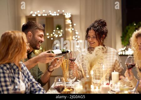 Fröhliche Freunde mit Rotwein auf der weihnachtsfeier Stockfoto