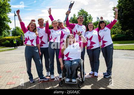 Windsor und Eton, Großbritannien. 6.. Juli 2022. Batonbearers posieren vor Windsor Castle mit dem Baton der Königin während des Baton Relay der Königin. Das Queen's Baton befindet sich derzeit auf einer 25-tägigen Tour durch die englischen Regionen auf dem Weg zu den Commonwealth Games. Kredit: Mark Kerrison/Alamy Live Nachrichten Stockfoto