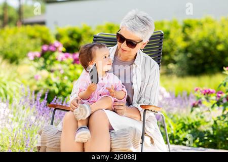 Großmutter und kleine Enkelin mit Telefon Stockfoto