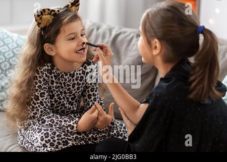 Mädchen, die zu Hause an halloween Gesichtsbemalung machen Stockfoto