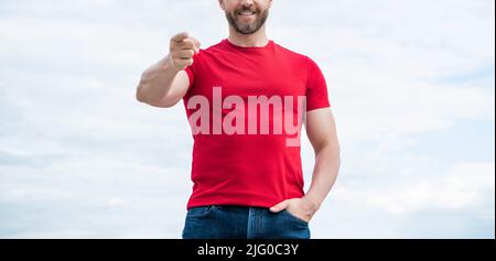 Beschnittene Ansicht des gestikulierenden Mannes im roten Hemd im Freien auf dem Hintergrund des Himmels Stockfoto