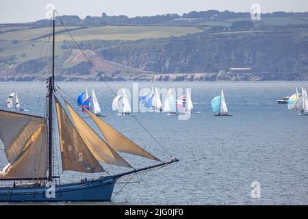 Das klassische Segelschiff fährt an einer Flotte von Drachenyachten vorbei, die in Falmouth Bay Rennen Stockfoto