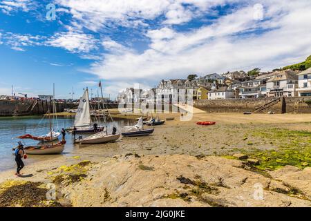 Eine Flotte von Wanderjinghies fuhr auf dem Sand für eine Mittagspause im St. Mawes Harbour, Carrick Roads, Cornwall Stockfoto