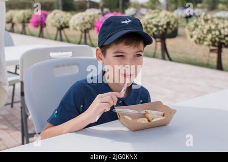 Ein Junge isst japanisches Essen in einem Restaurant Stockfoto