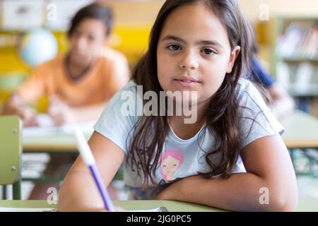 Nahaufnahme eines kleinen kaukasischen Mädchens während einer Schulklasse. Konzept des Lernens, der Bildung und der Entwicklung im Kinderalter. Stockfoto