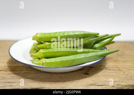 Stapel von frischen Okra auf Holzhintergrund, Gartenarbeit Bio grüne Obst sterben Gemüse Stockfoto