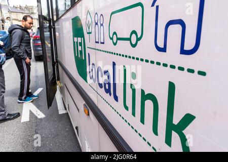 Rural Transport Program/TFI Local Link Bus in Donegal Town, County Donegal, Irland. Passagiere steigen in den Bus ein. Stockfoto