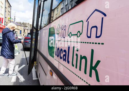 Rural Transport Program/TFI Local Link Bus in Donegal Town, County Donegal, Irland. Passagiere steigen in den Bus ein. Stockfoto