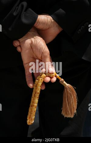 Der muslimische Mann hält die muslimischen Gebetsperlen, die als Misbaha oder tasbih tespih bekannt sind, im Innenhof der Selimiye-Moschee (Selimiye Camii) in Edirne, Türkei. Stockfoto