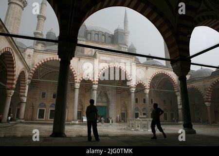 Im Innenhof der Selimiye-Moschee (Selimiye Camii) in Edirne, Türkei, warten Menschen auf den Regen. Die Moschee, die vom osmanischen kaiserlichen Architekten Mimar Sinan entworfen wurde, wurde zwischen 1568 und 1575 erbaut. Die Säulen, die den Innenhof flankierten, wurden aus den byzantinischen Kirchen entfernt. Stockfoto