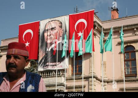 Kırkpınar (Türkisches Ölwrestling). Turniermusiker, der vor dem riesigen Porträt von Mustafa Kemal Atatürk abgebildet ist, das mit türkischen Nationalflaggen auf dem Gebäude des Rathauses von Edirne während der Eröffnungsfeier des Kırkpınar-Turniers 648. in Edirne, Türkei, am 3. Juli 2009 geschmückt ist. Stockfoto