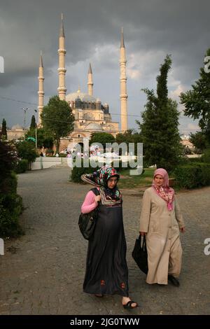 Türkische Frauen in traditioneller Kleidung gingen vor der Selimiye Moschee (Selimiye Camii) in Edirne, Türkei. Die Moschee, die vom osmanischen kaiserlichen Architekten Mimar Sinan entworfen wurde, wurde zwischen 1568 und 1575 erbaut. Stockfoto