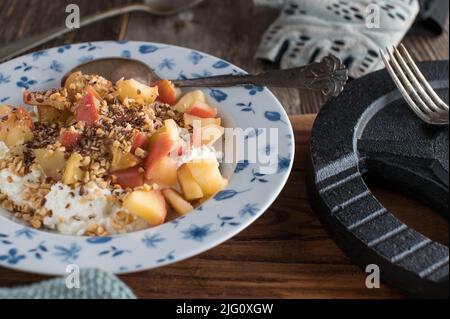 Bodybuilding-Frühstück mit proteinreichem Hüttenkäse, gekochten Äpfeln, gerösteten Haselnüssen und Leinsamen Stockfoto