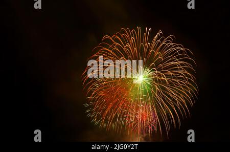Spektakuläres rotes Goldfeuerwerk, das am Nachthimmel planscht Stockfoto