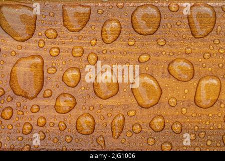 Horizontaler Hintergrund aus lackiertem verbranntem Holz mit glänzenden Wassertropfen aus dem Regen, nassen Holzplanken Stockfoto