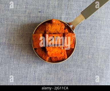 Paneer Rogan josh, indische Kashmiri-Küche aus Hüttenkäse und Kräutern hat dicke Soße.Nahaufnahme der Schüssel auf hellblauem Hintergrund.Platz kopieren. Stockfoto