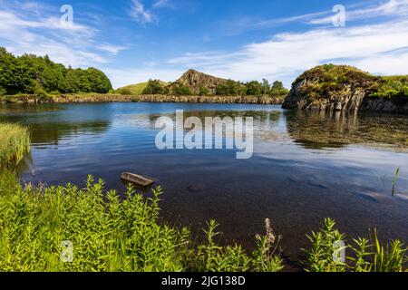 Die Felswand des Sees und der Whin Sill am Cawfields Quarry an der Hadrianmauer, Northumberland, England Stockfoto