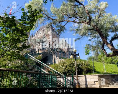 Fairmont Chateau Frontenac Blick von der Frontenac Treppe im Sommer. Natürlicher Rahmen aus Bäumen. Stockfoto