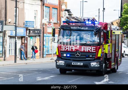 Feuerwehrmotor der Londoner Feuerwehr mit blauen Lichtern in der High Street in South London Stockfoto