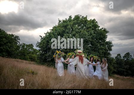 London, Großbritannien. 6.. Juli 2022. Britisch-Ukrainer feiern Ivana-Kupala im Greenwich Park. Der Ivan Kupala Tag, auch bekannt als Ivana-Kupala oder Kupala Nacht, ist ein traditionelles heidnisches Feiertag Volksfest in den ostslawischen Kulturen. Mädchen kreieren und tragen Blumenkränze und führen verschiedene Rituale durch. Zunächst war Ivana-Kupala ein heidnischer Fruchtbarkeitsritus, der auch mit der Feier der Sommersonnenwende verbunden war, wenn die Nächte die kürzesten sind. Nach dem Eintreffen des Christentums waren die Riten mit dem christlichen Fest der Geburt Johannes des Täufers verflochten. Kredit: Guy Corbishley/Alamy Live Nachrichten Stockfoto