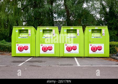 Reihe mit vier Recycling-Behältern für Kleidung und Schuhe aus Metall Stockfoto