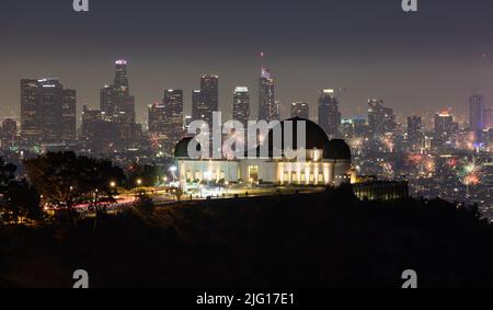 Feuerwerk über dem Griffith Observatory mit der Skyline von Los Angeles in der Ferne Stockfoto