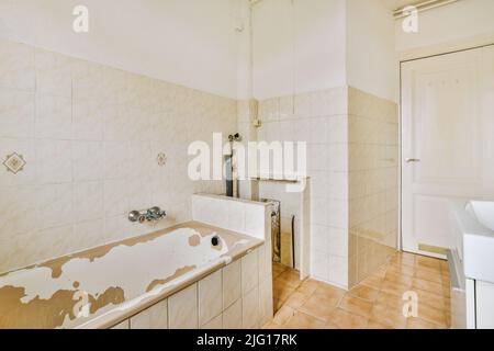 Waschbecken mit Spiegeln und sauberer Badewanne im modernen Badezimmer mit weiß gefliesten Wänden Stockfoto