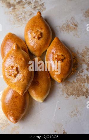 Gebratene hausgemachte Kuchen mit Kartoffeln auf dem Küchentisch. Omas Rezept. Blick von oben Stockfoto