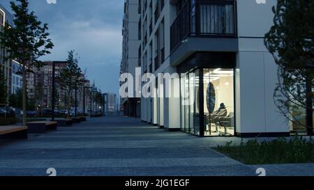 Moderne Stadtstraße an einem Sommertag am Abend. Archivmaterial. Gebäude eines neuen modernen Schlafbereichs auf blauem bewölktem Himmel Hintergrund Stockfoto