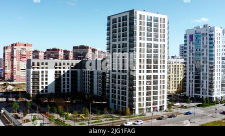 Schöne Landschaft von einer Drohne.Stock Footage.hohe neue Gebäude und Ziegelhäuser nebeneinander, umgeben von Parks, Bäumen und Parkplätzen Stockfoto