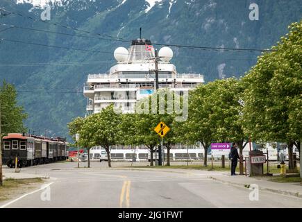 Skagway, AK - 6. Juni 2022: White Pass Touristenzug von Viking Orion Kreuzschiff im Dock Stockfoto