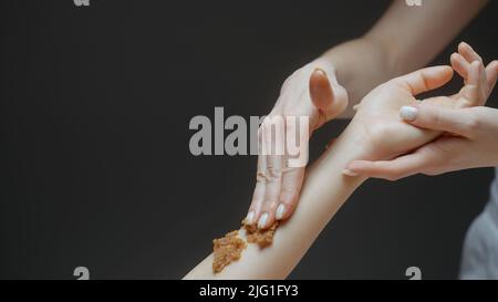 Frau genießen eine Zucker Meersalz natürlichen Körper Peeling Peeling Behandlung mit professioneller Kosmetikerin. Aktion. Konzept von Schönheit und Körperpflege Stockfoto