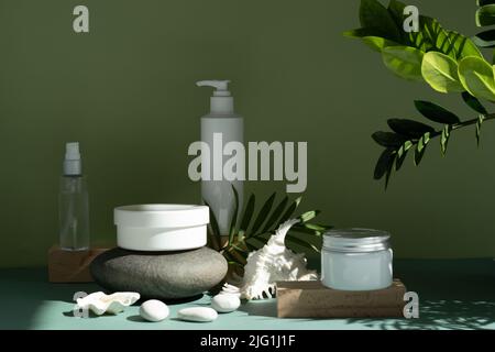 Weiße Röhre auf grünem Hintergrund. Vorderansicht Foto in hoher Qualität. Öko-Kosmetik auf einem Podium aus Stein. Stockfoto