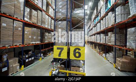 Moskau - Russland, 04.20.2022: Lager mit Kartons im Inneren auf Paletten Regale, Logistikzentrum. Kreativ. Riesige, große moderne Lagerhalle gefüllt wi Stockfoto