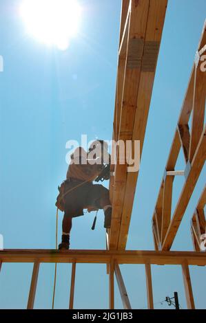 Lateinischen Belegschaft Gebäude Holzstab gebaut Haus Hause schneiden Maßnahme Nagelung an heißen Tag Stockfoto