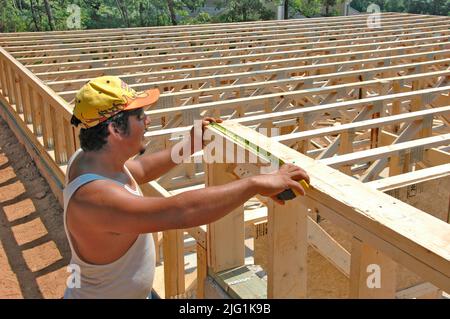 Lateinischen Belegschaft Gebäude Holzstab gebaut Haus Hause schneiden Maßnahme Nagelung an heißen Tag Stockfoto