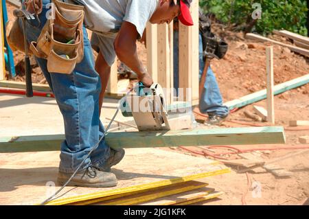 Lateinischen Belegschaft Gebäude errichtet Haus Hause schneiden Maßnahme Nagelung an heißen Tag unsicher Sie keine Wache am Holzstab sah gefährlich Stockfoto