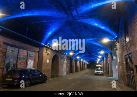 Erstaunliche Lichter auf den dunklen Bögen unter dem Bahnhof von Leeds, Stadtzentrum von Leeds, West Yorkshire, Großbritannien. Stockfoto