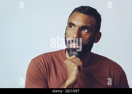 Headshot-Porträt eines hübschen bärtigen Mannes mit mittlerem Erwachsenen, der lächelt und vor grauem Hintergrund in den Kopierraum schaut Stockfoto